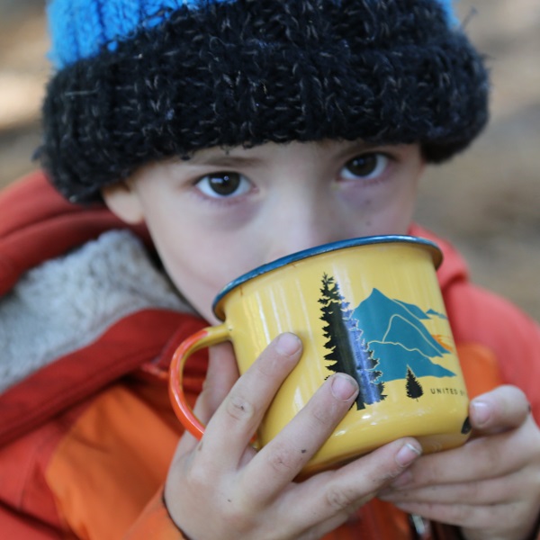 child drinking hot chocolate from mug