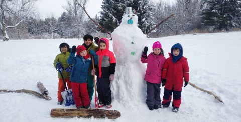 Nature School students pose with their completed snowperson