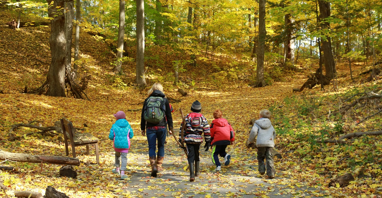 parent leads children on a fall hike on a trail at Kortright Centre for Conservation